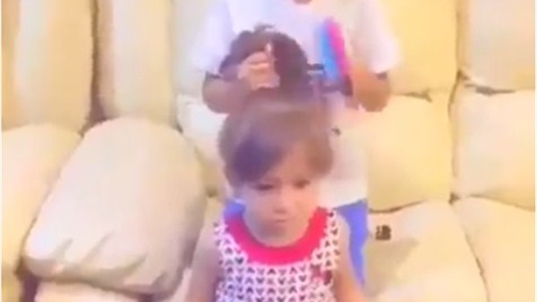 طفل يمشط شعر شقيقته