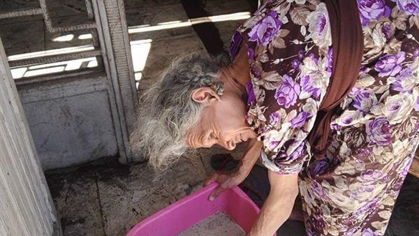 عجوز تقوم بمسح السلالم