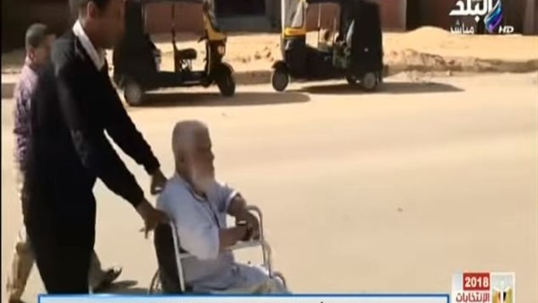 شرطي يساعد مسنًا